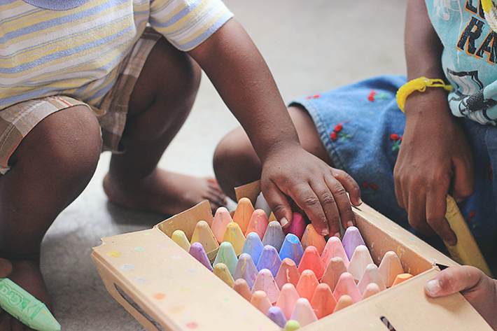 Lapset leikkivät värikkäillä liiduilla.